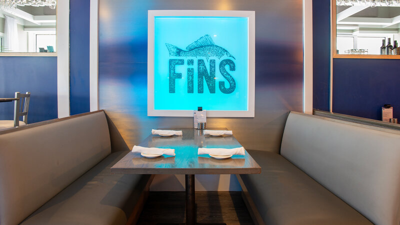 Booth seating with Fins logo on wall